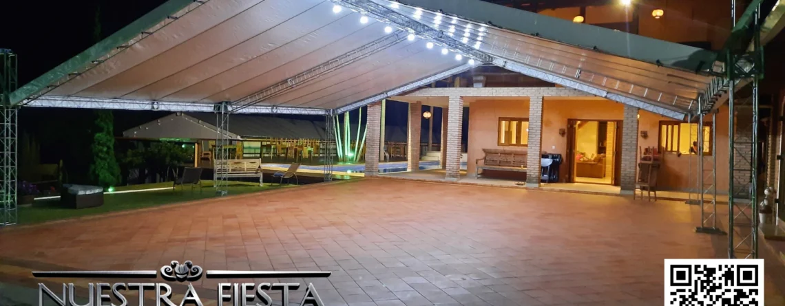 Tenda de 12x12 metros da NUESTRA FIESTA montada à noite, iluminada para criar um ambiente acolhedor e elegante.