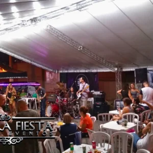 Tenda da NUESTRA FIESTA em um evento, abrigando um pequeno palco montado para apresentações.