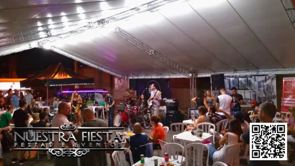 Tenda da NUESTRA FIESTA em um evento, abrigando um pequeno palco montado para apresentações.