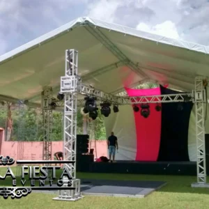 Tenda de 12x12 metros com altura lateral de 5 metros da NUESTRA FIESTA, cobrindo um palco com sistema de iluminação instalado abaixo.