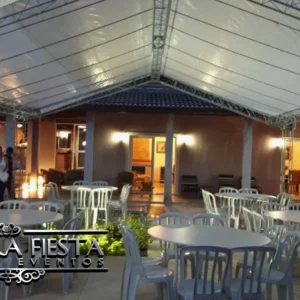 Tenda pequena da NUESTRA FIESTA iluminada à noite, proporcionando um ambiente acolhedor para um encontro familiar.