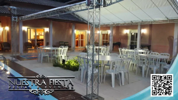 Tenda pequena da NUESTRA FIESTA montada à noite no jardim da casa do cliente, criando um ambiente aconchegante para um encontro familiar.