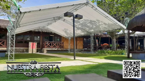 Tenda da NUESTRA FIESTA montada no jardim de um restaurante, criando um espaço elegante e acolhedor ao ar livre.