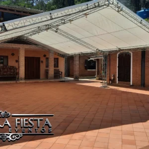 Tenda da NUESTRA FIESTA montada em um espaço normalmente usado como estacionamento na casa do cliente, ampliando a área disponível para receber convidados.